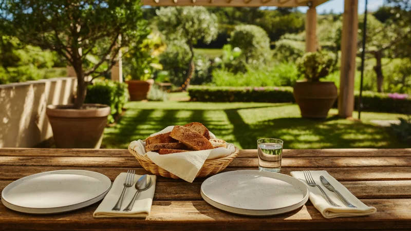 Tavolo da giardino sotto il pergolato con piatti, pane e acqua